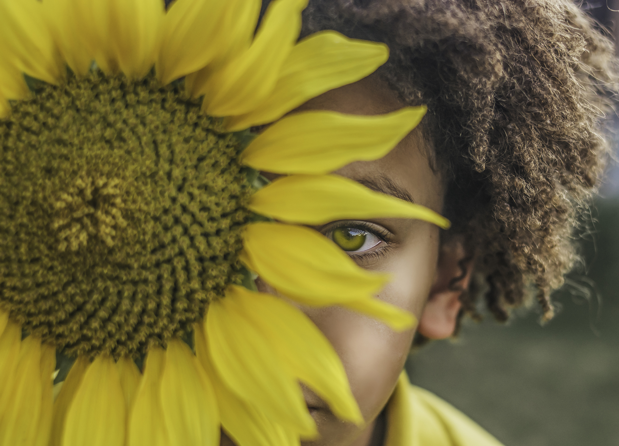 photography of child posing with yellow flower